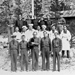 Cooks, Drivers, Commanders in front of flagpole and barracks, CCC camp
